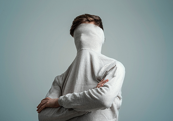 Person mit verstecktem Gesicht als Symbol für eingeschränkte Lebensqualität bei Neurodermitis