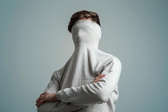 Person mit verstecktem Gesicht als Symbol für eingeschränkte Lebensqualität bei Neurodermitis